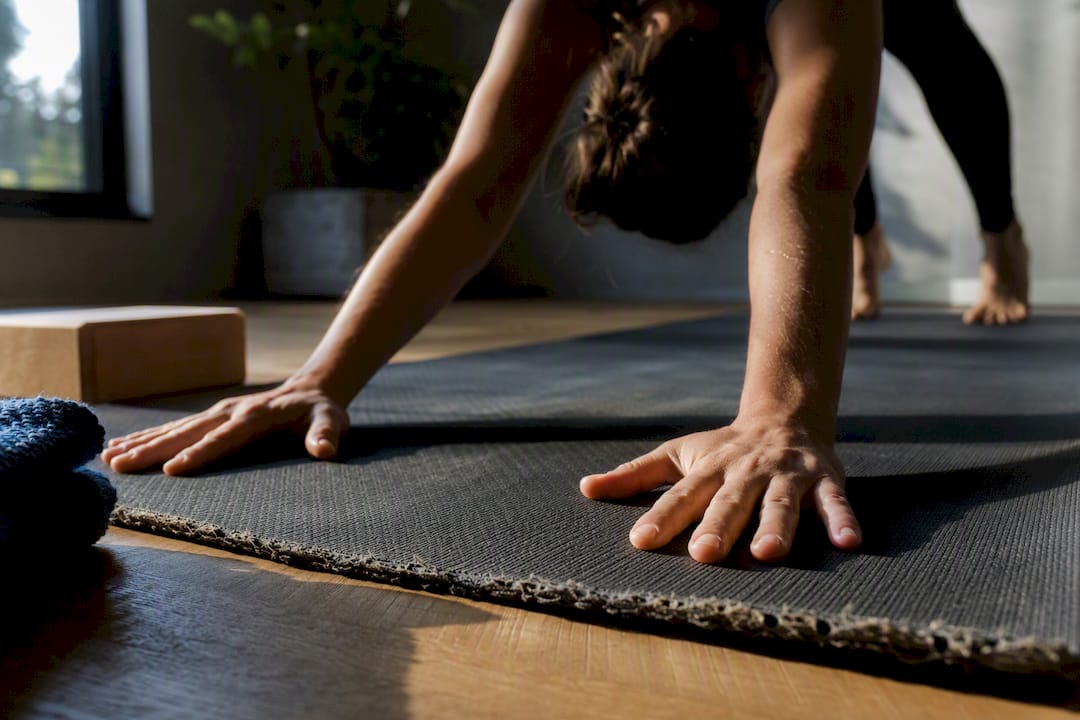 Practitioner checking worn yoga mat traction