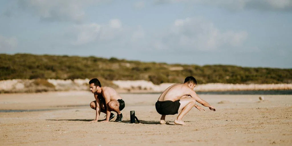 two men sitting on sand