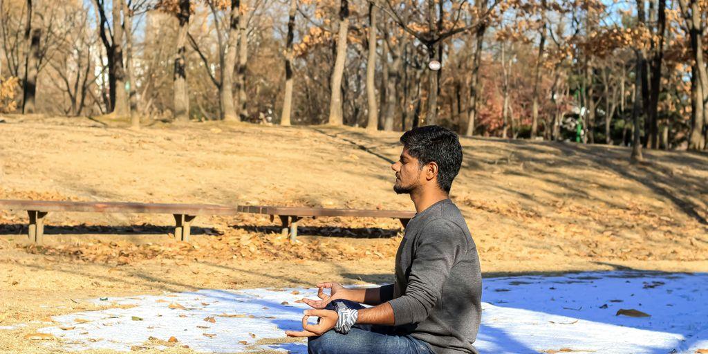a man sitting on the ground in a park