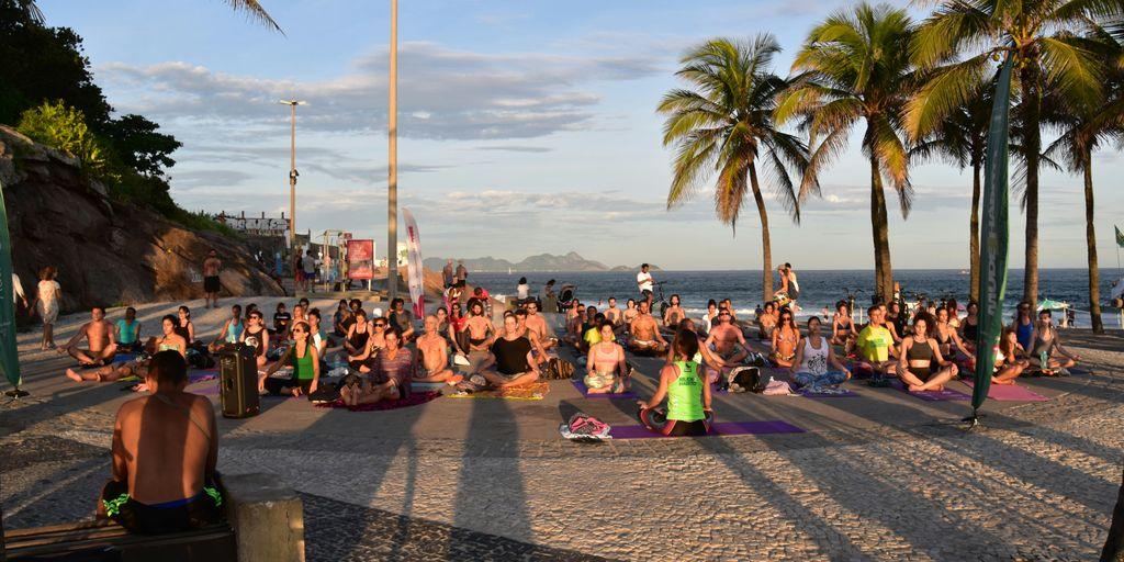 a group of people sitting on top of a sandy beach