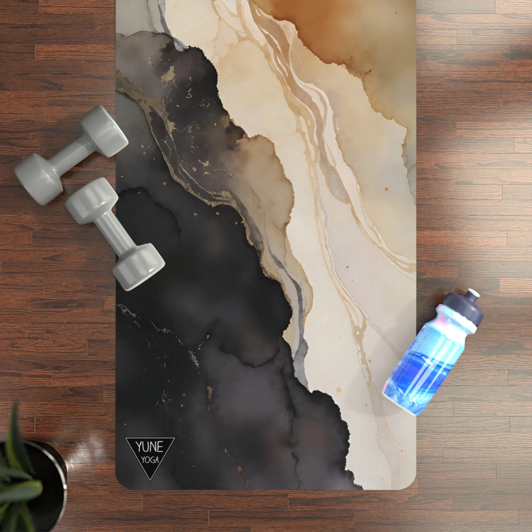 Abstract marble print yoga mat on wooden floor with gray dumbbells and blue water bottle