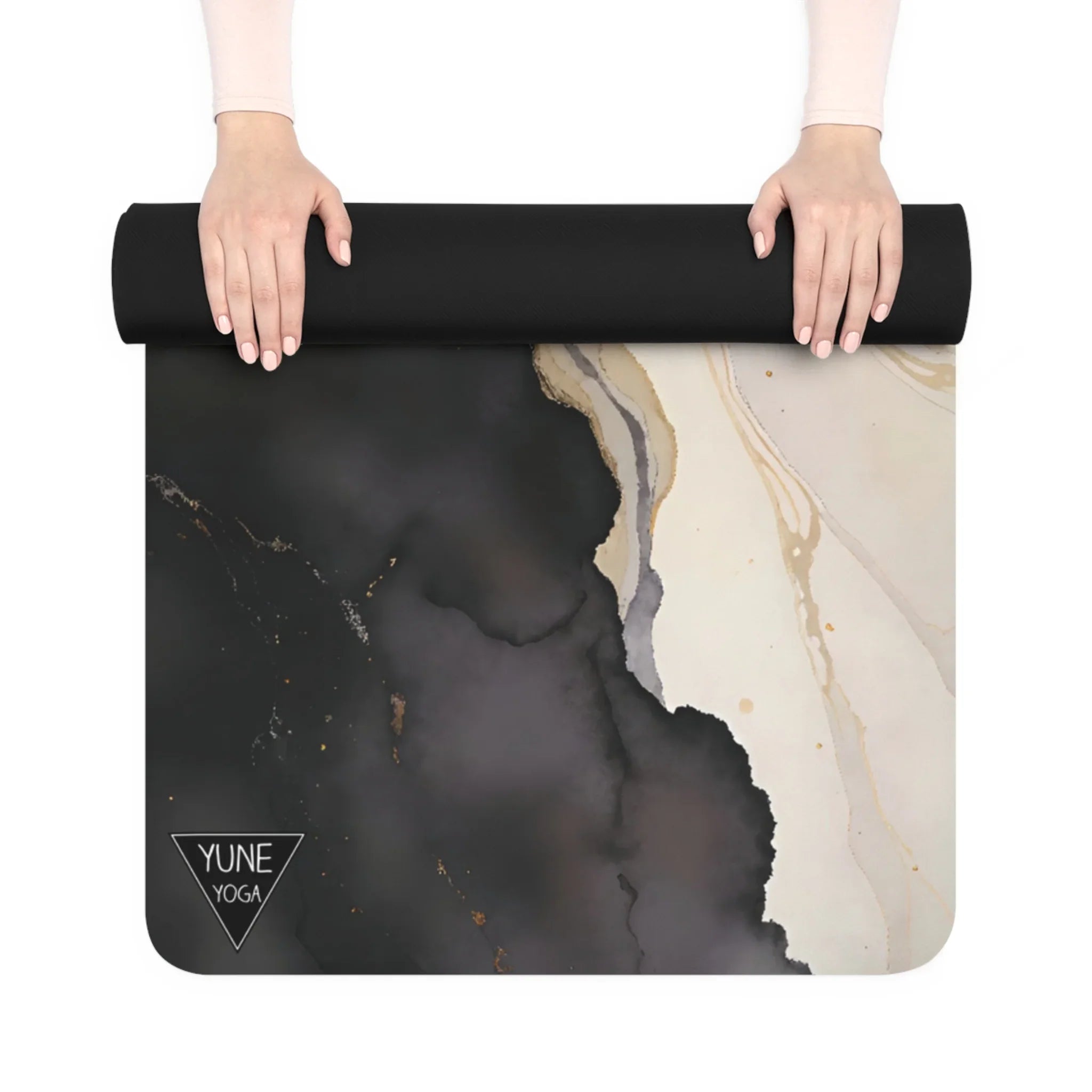 Hands unrolling a black marble pattern yoga mat with abstract design