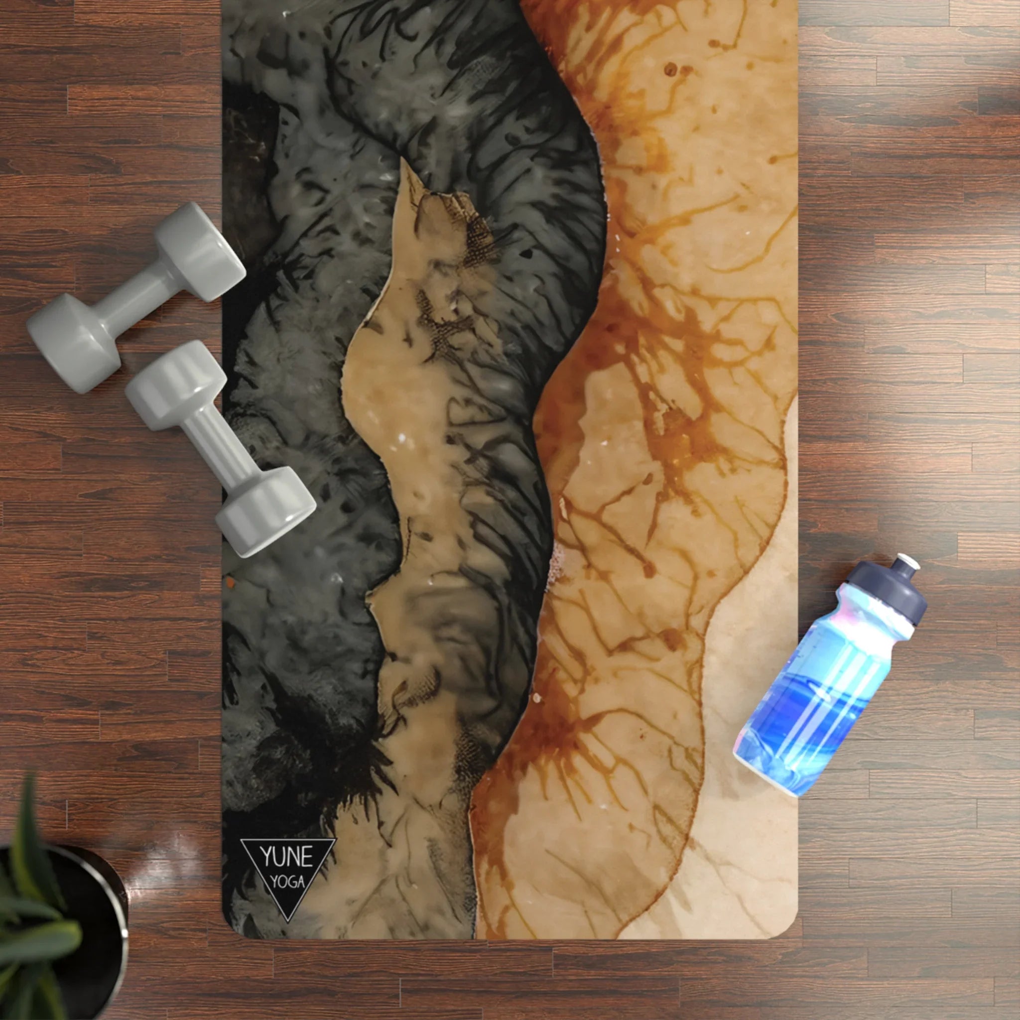 Abstract patterned yoga mat on wood floor with dumbbells and water bottle nearby