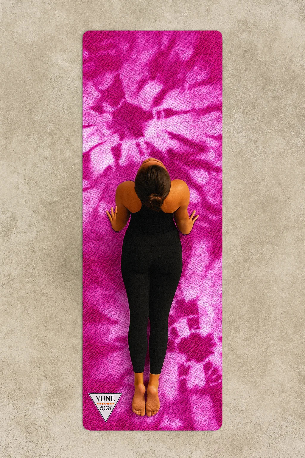 Person lying on a pink tie-dye yoga mat with 'Vinyasa' branding.