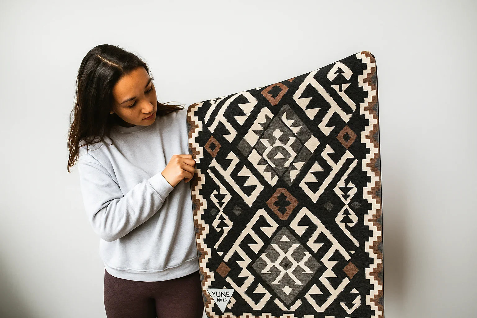 Woman holding a patterned blanket against a white background