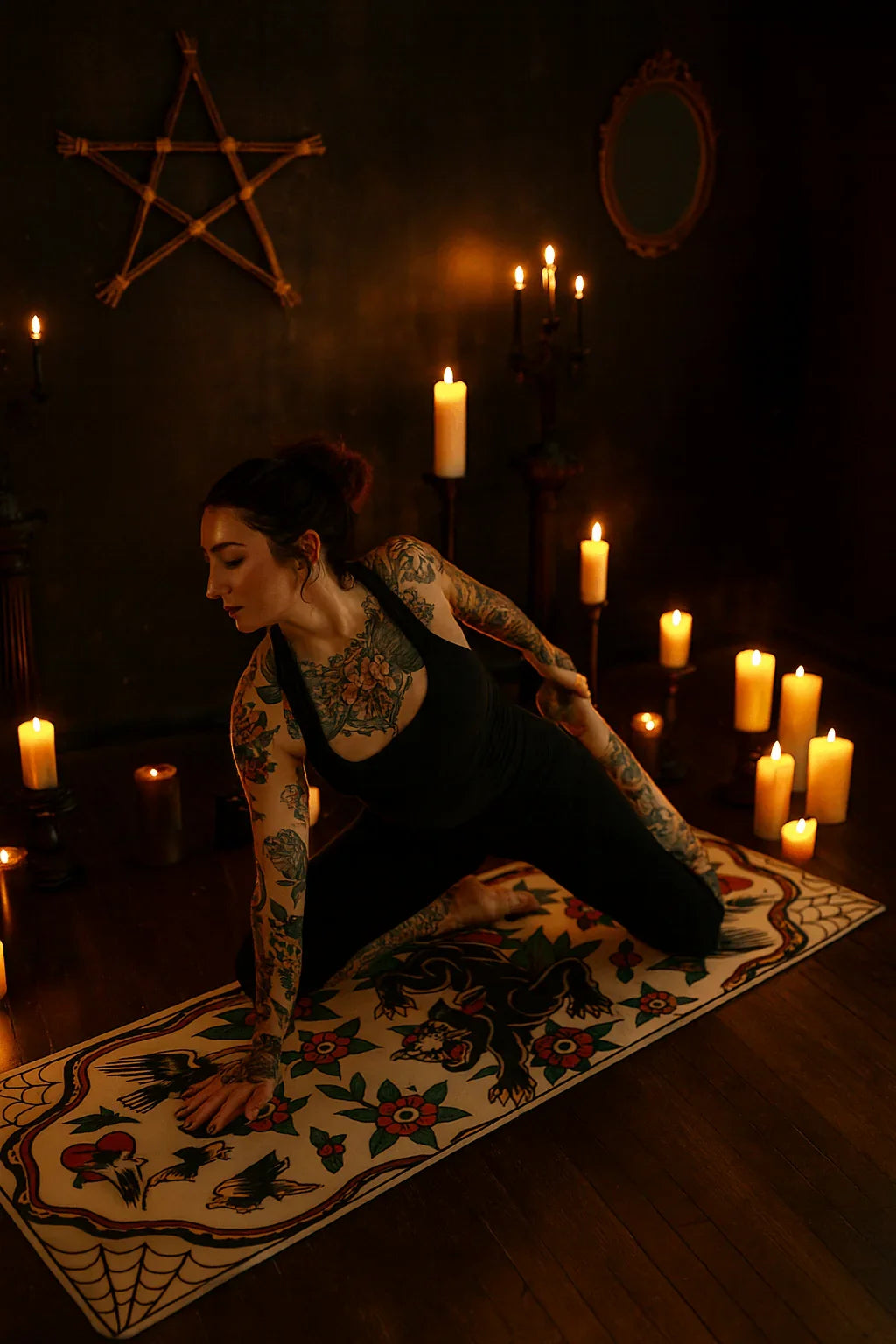 Woman with tattoos practicing yoga in a dimly lit room with candles and a pentagram symbol.