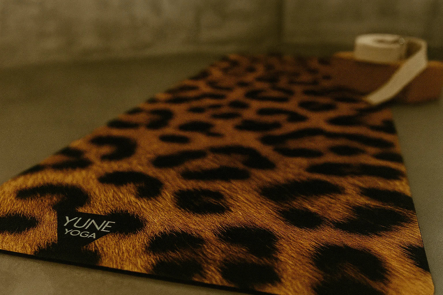 Leopard print yoga mat with 'YUNE YOGA' branding on a neutral background