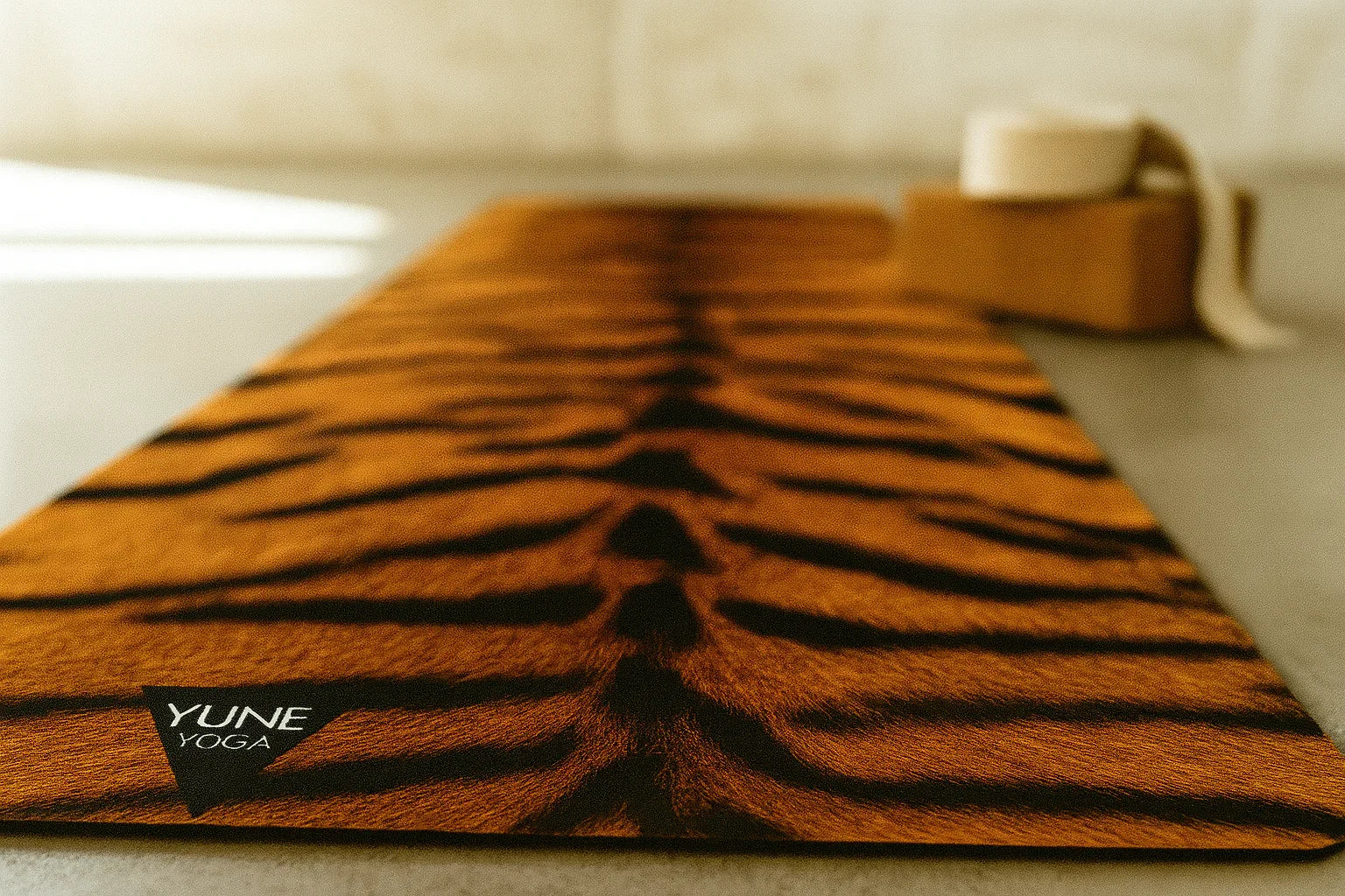 Yume Yoga mat with tiger stripe pattern on a neutral background