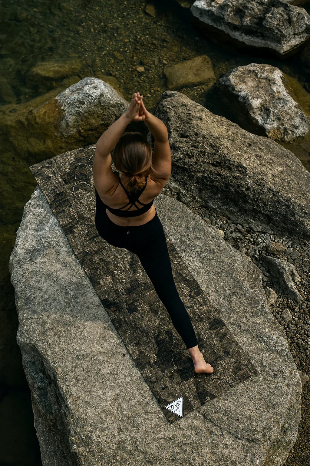Person practicing yoga on a rock with a scenic background