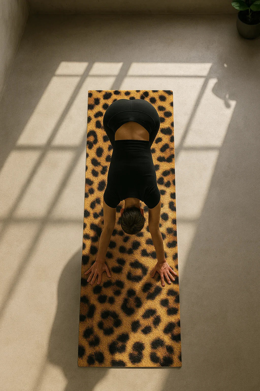 Person performing a yoga pose on a leopard print mat with shadows on the floor.