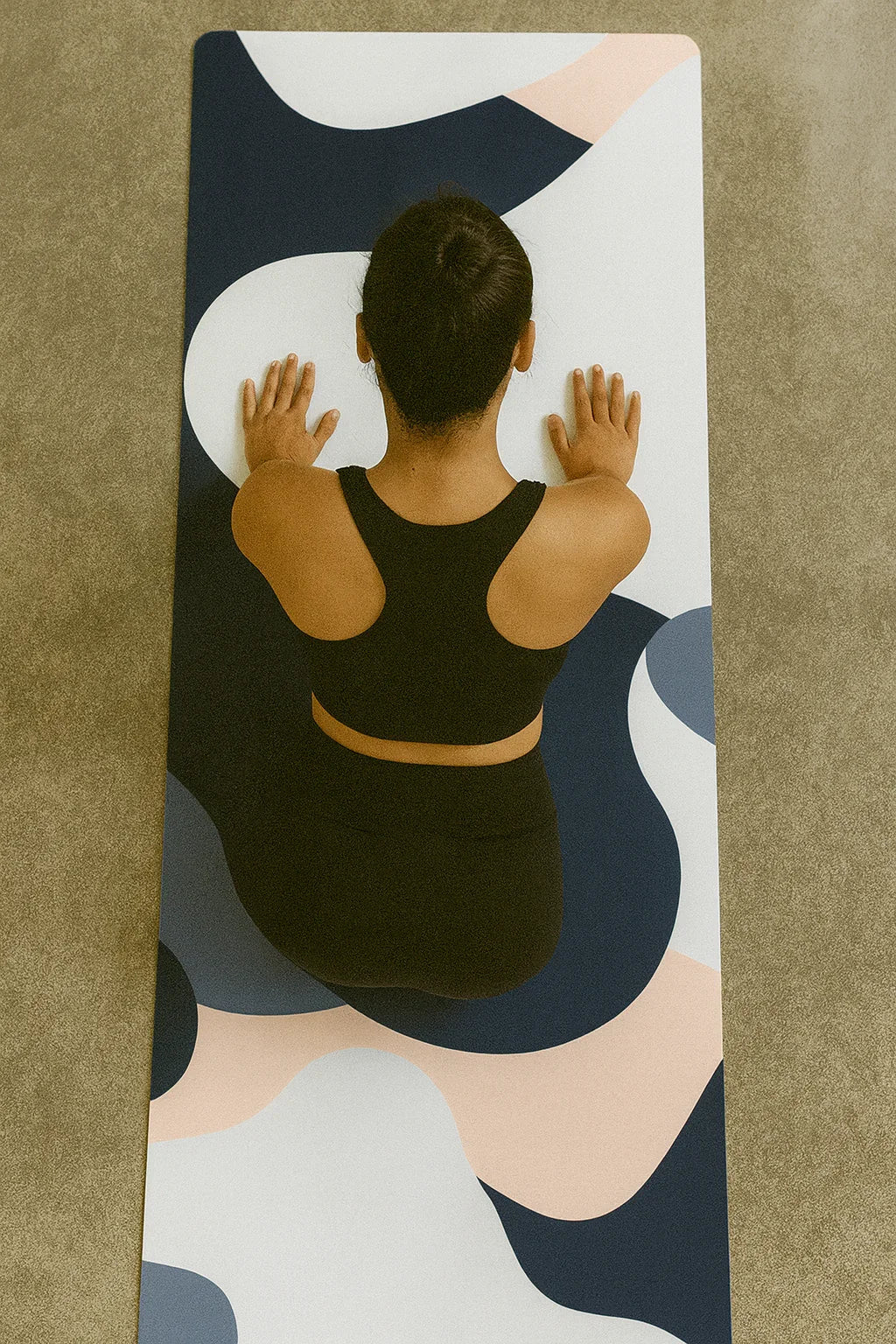Person practicing yoga on a colorful mat with a neutral background