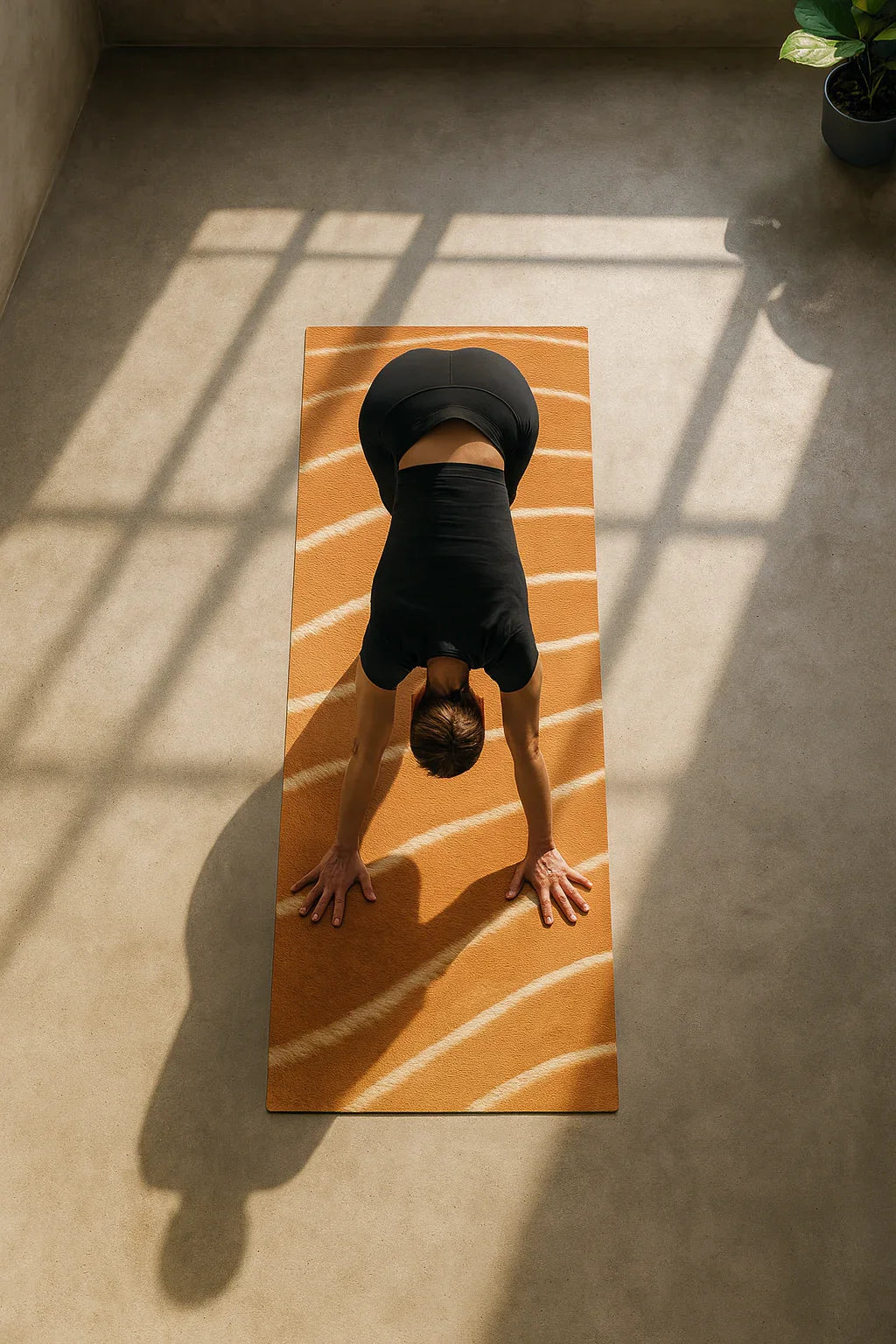 Person practicing yoga on a wooden mat with sunlight casting shadows on the floor.