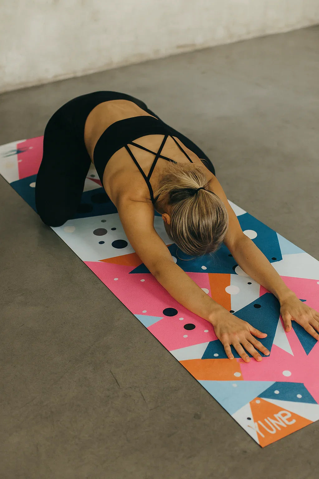 Person stretching on a colorful yoga mat in a home setting