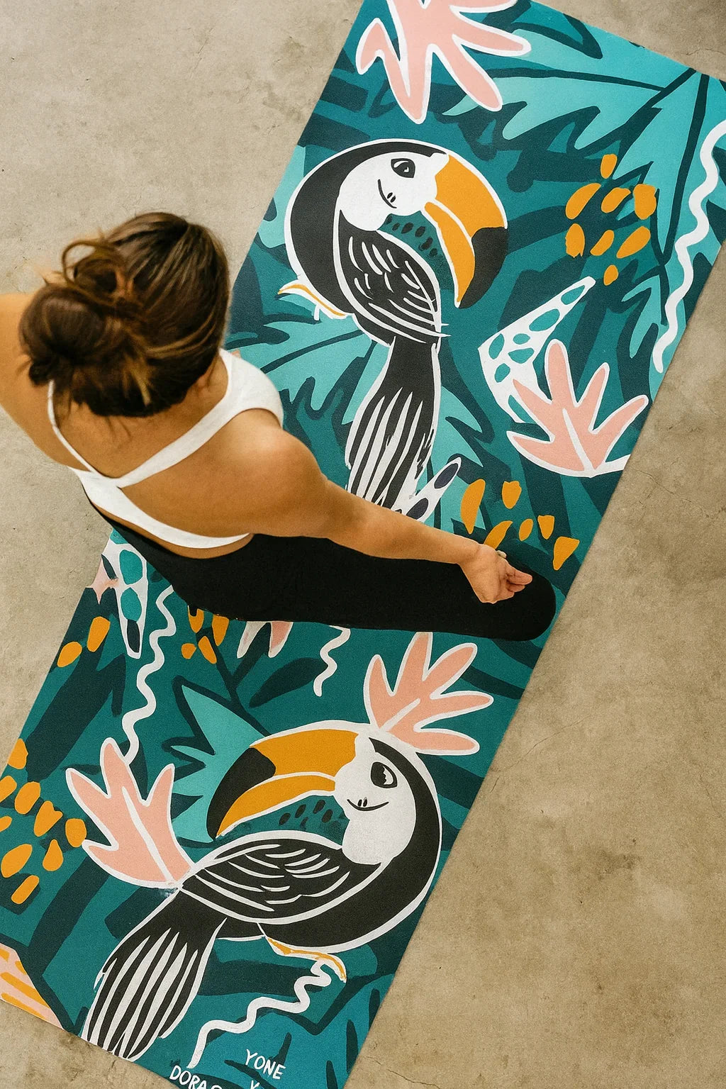 Person on a colorful yoga mat with toucan design