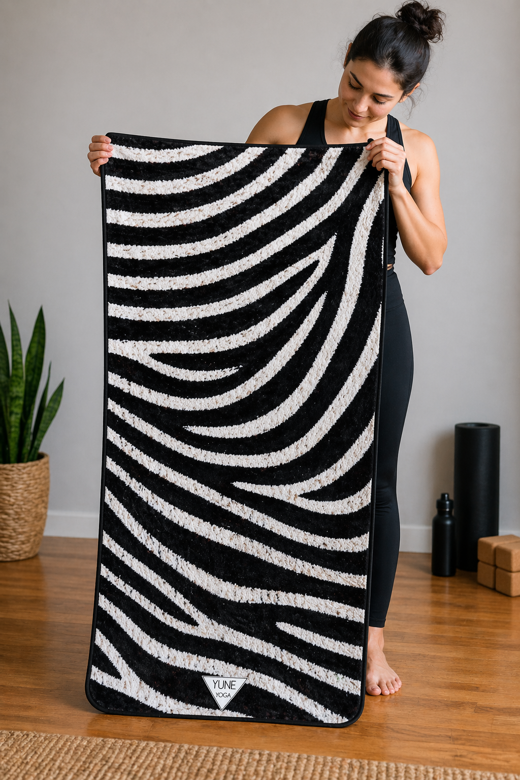Woman holding a black and white striped towel in a home setting