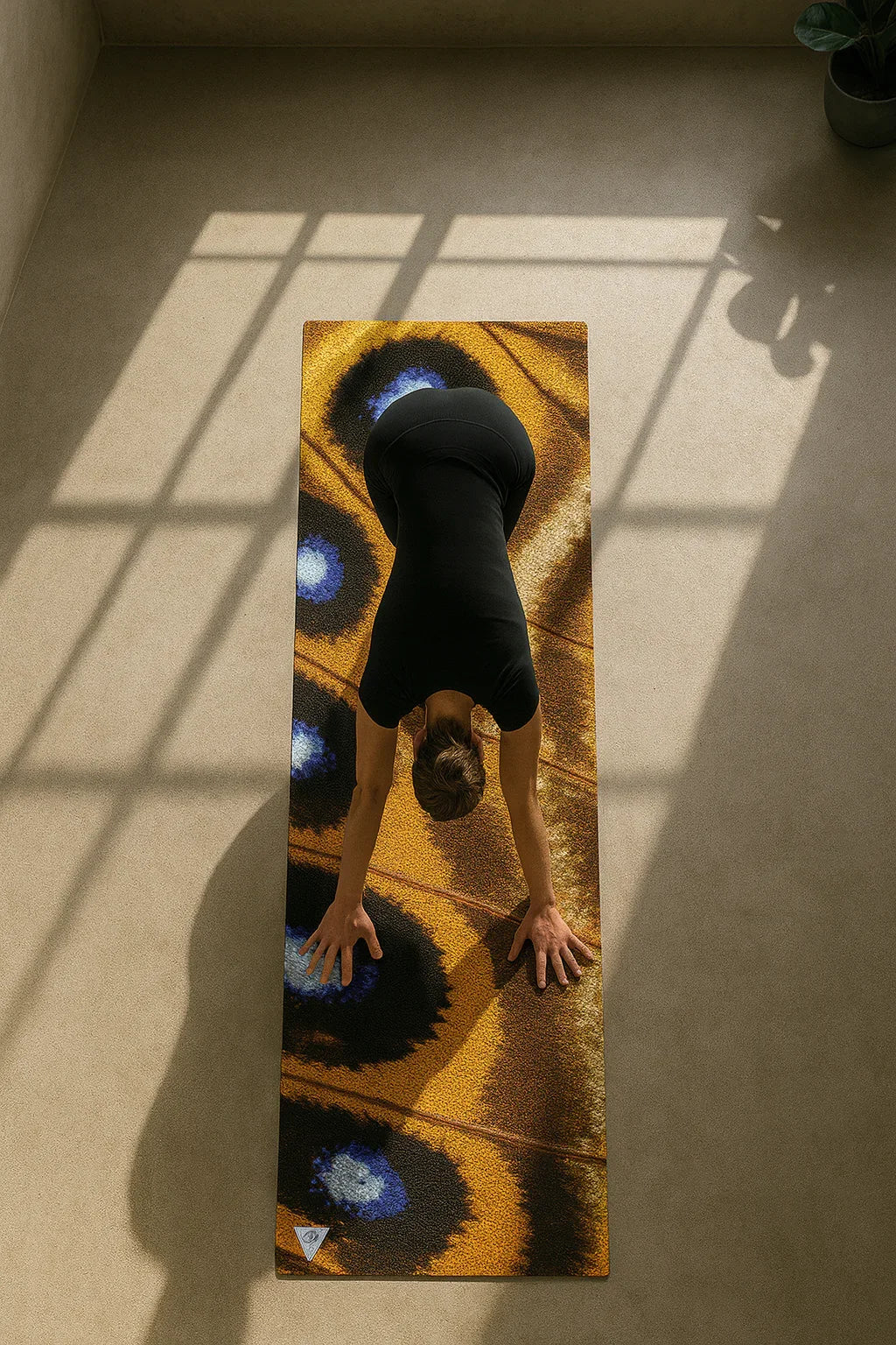 Person practicing yoga on a mat with abstract design in a sunlit room