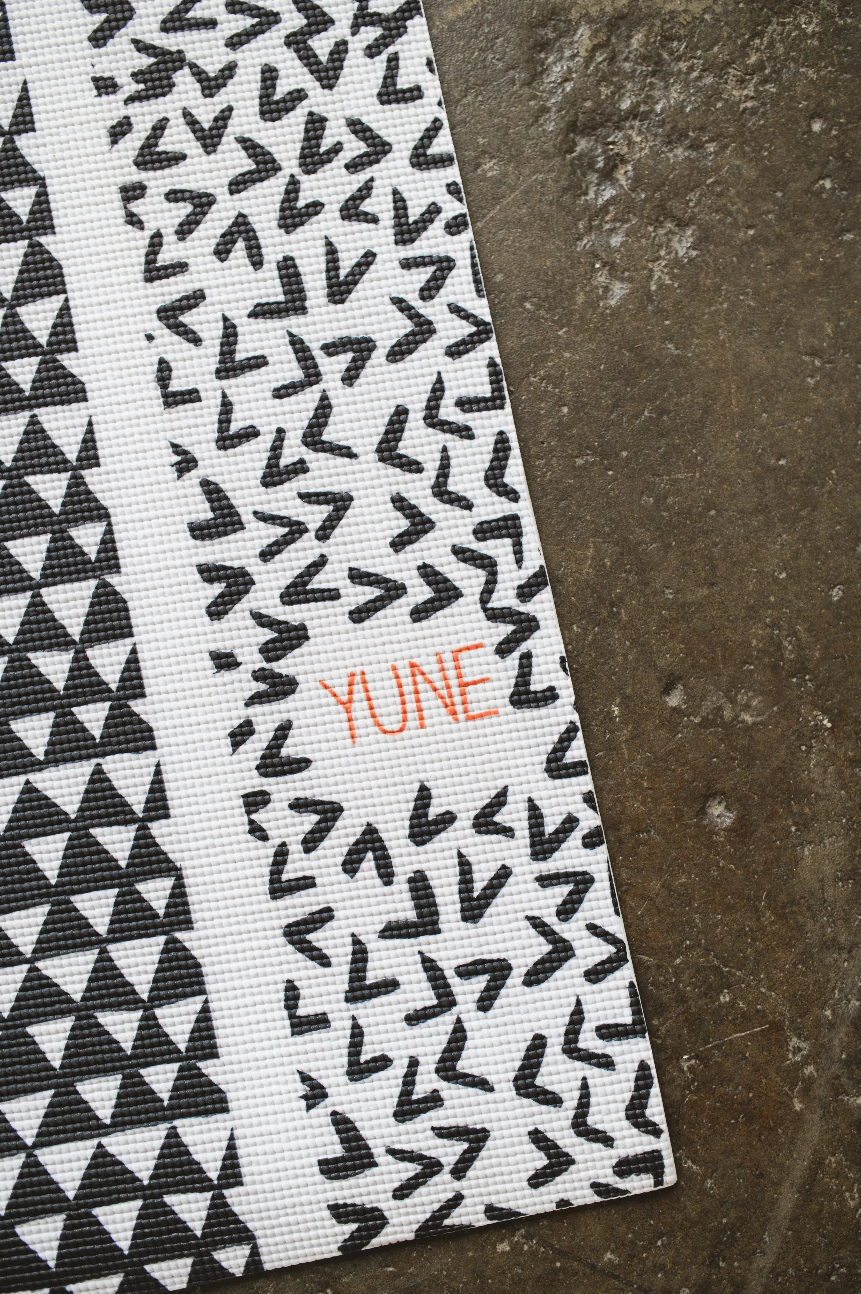 Textile with geometric pattern and 'YUHE' branding on a textured surface