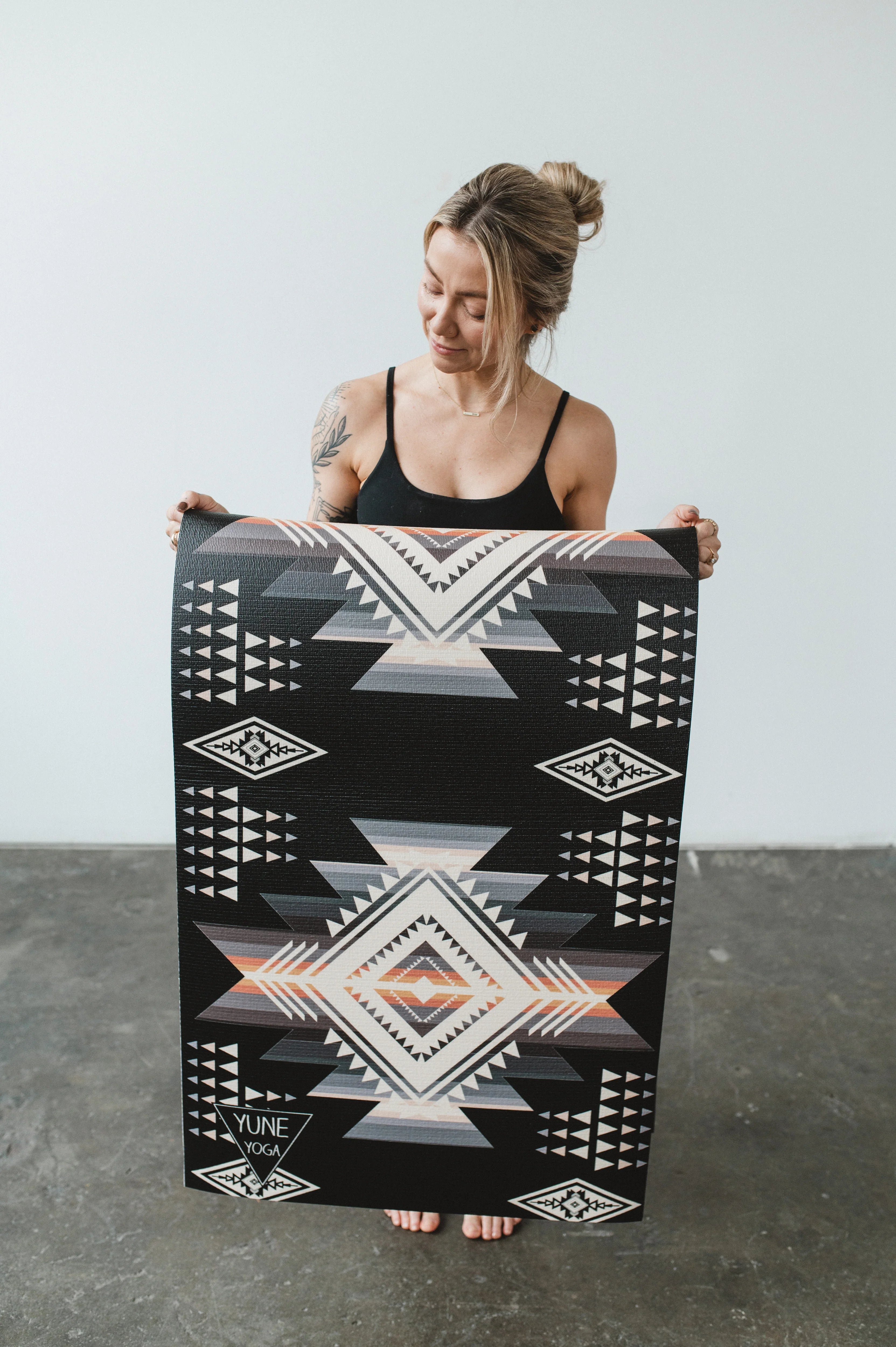 Woman holding a large black and white patterned rug