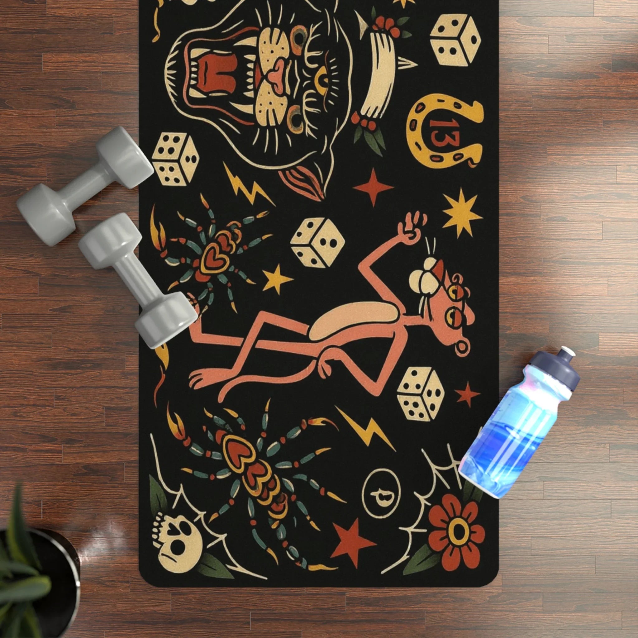 Yoga mat with colorful designs on a wooden floor with dumbbells and a water bottle.