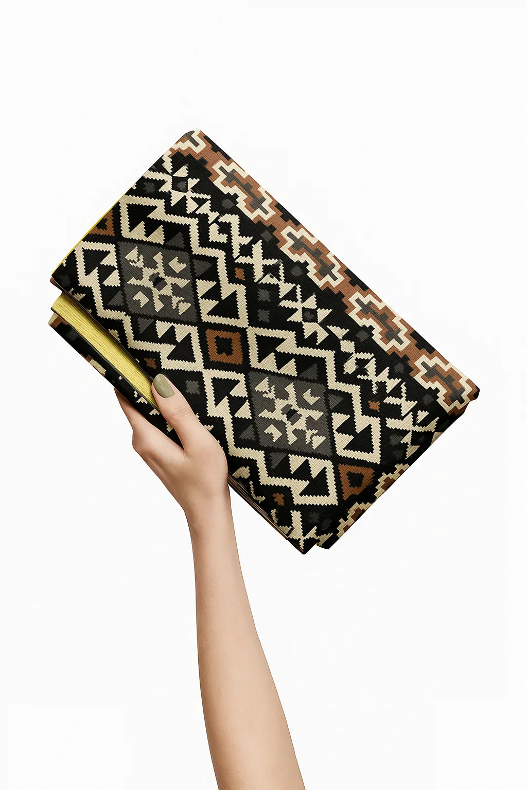 Hand holding a patterned clutch bag against a white background