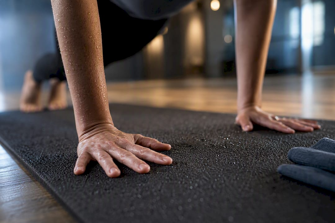 Palms gripping damp porous yoga mat