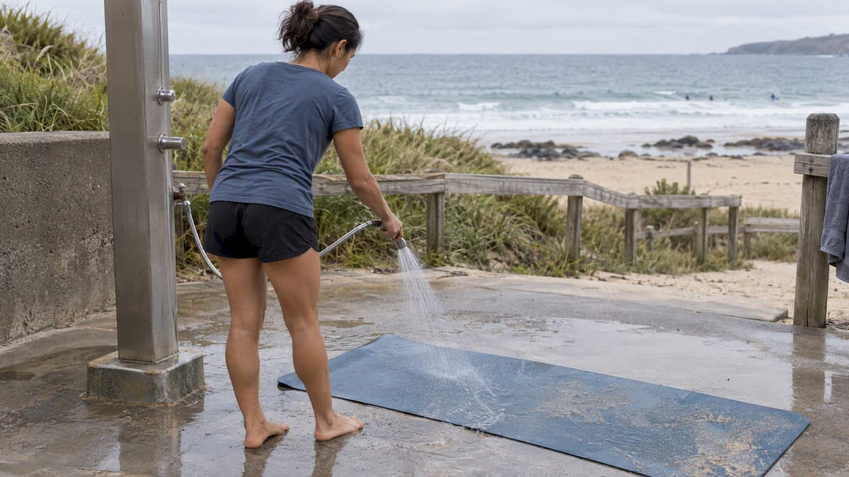 Rinsing sand from a yoga mat