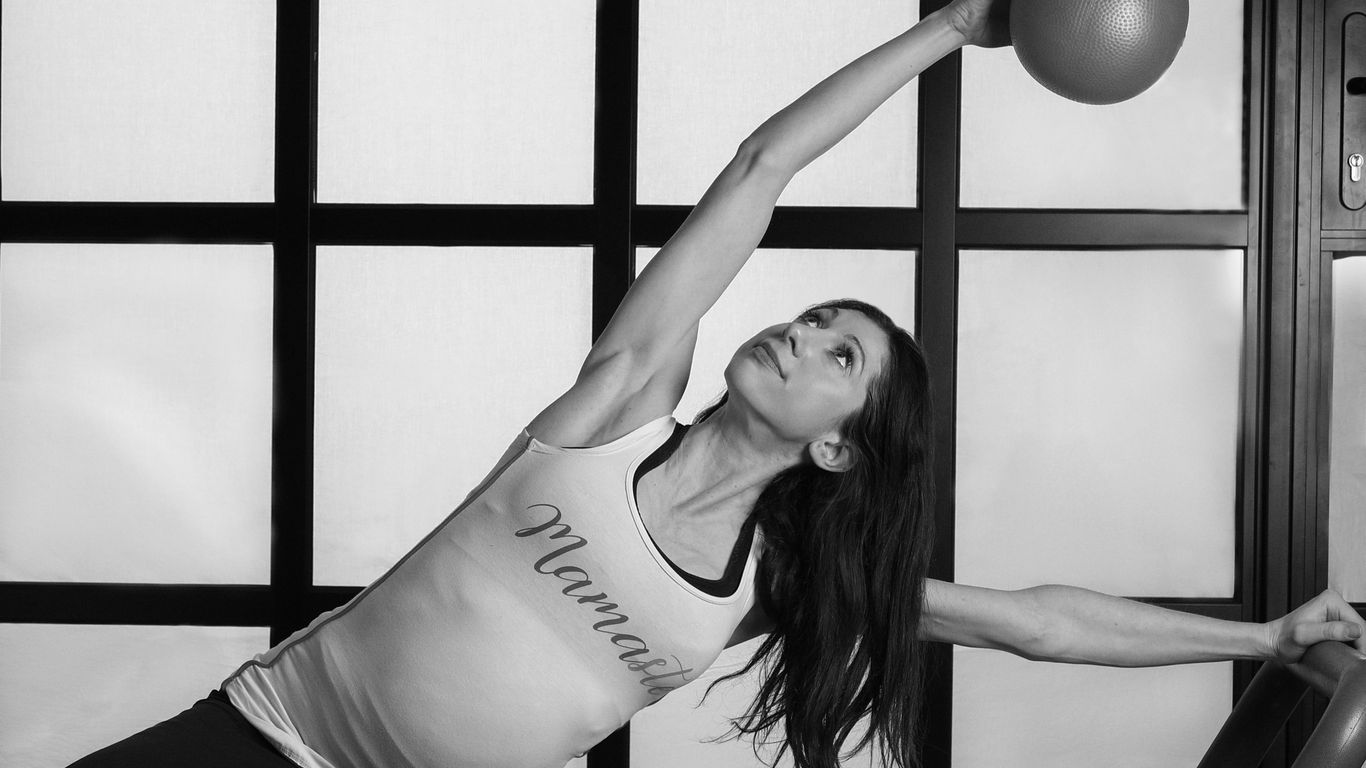 woman in white tank top and black shorts bending her body