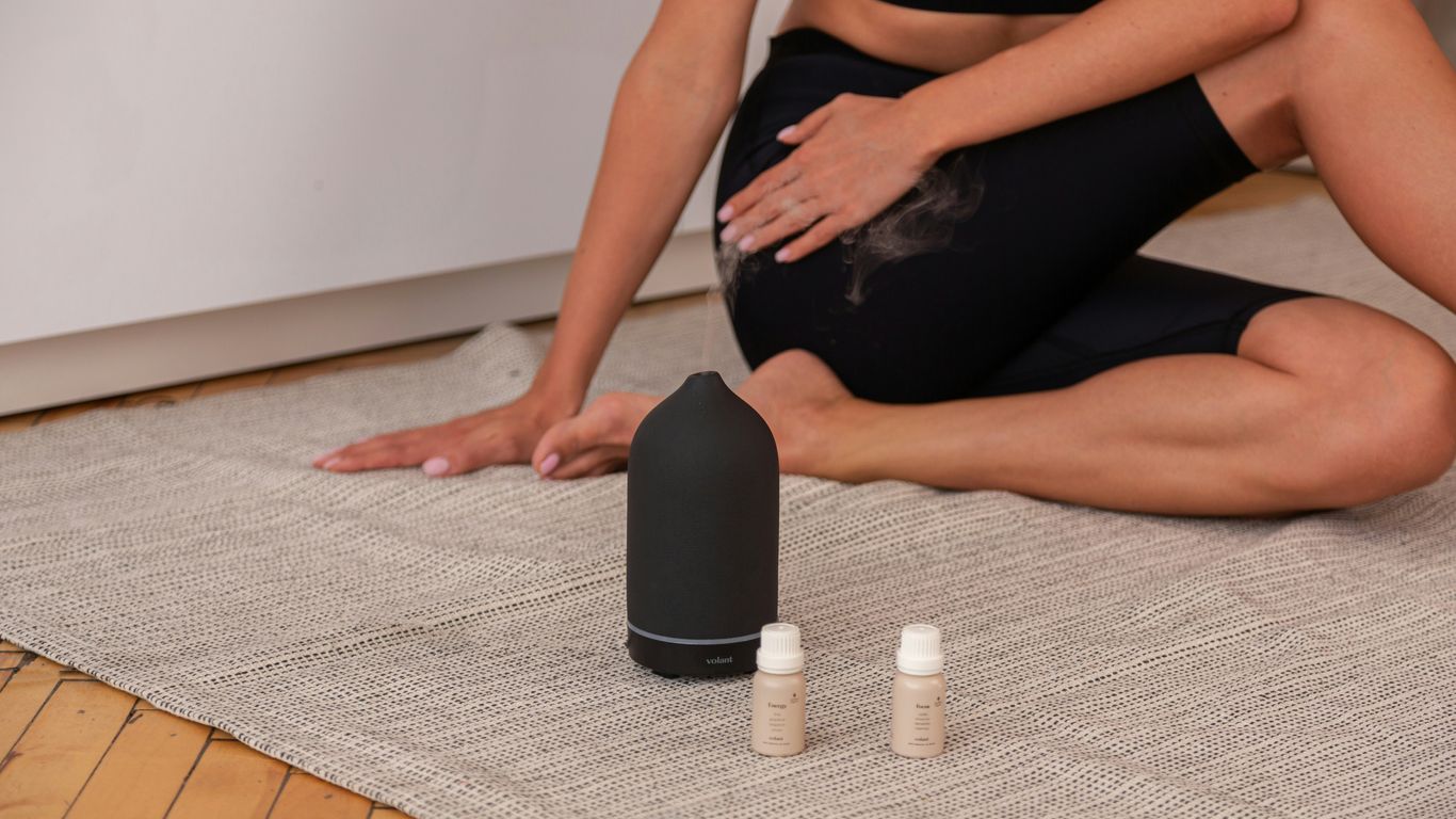 a woman sitting on the floor next to two bottles