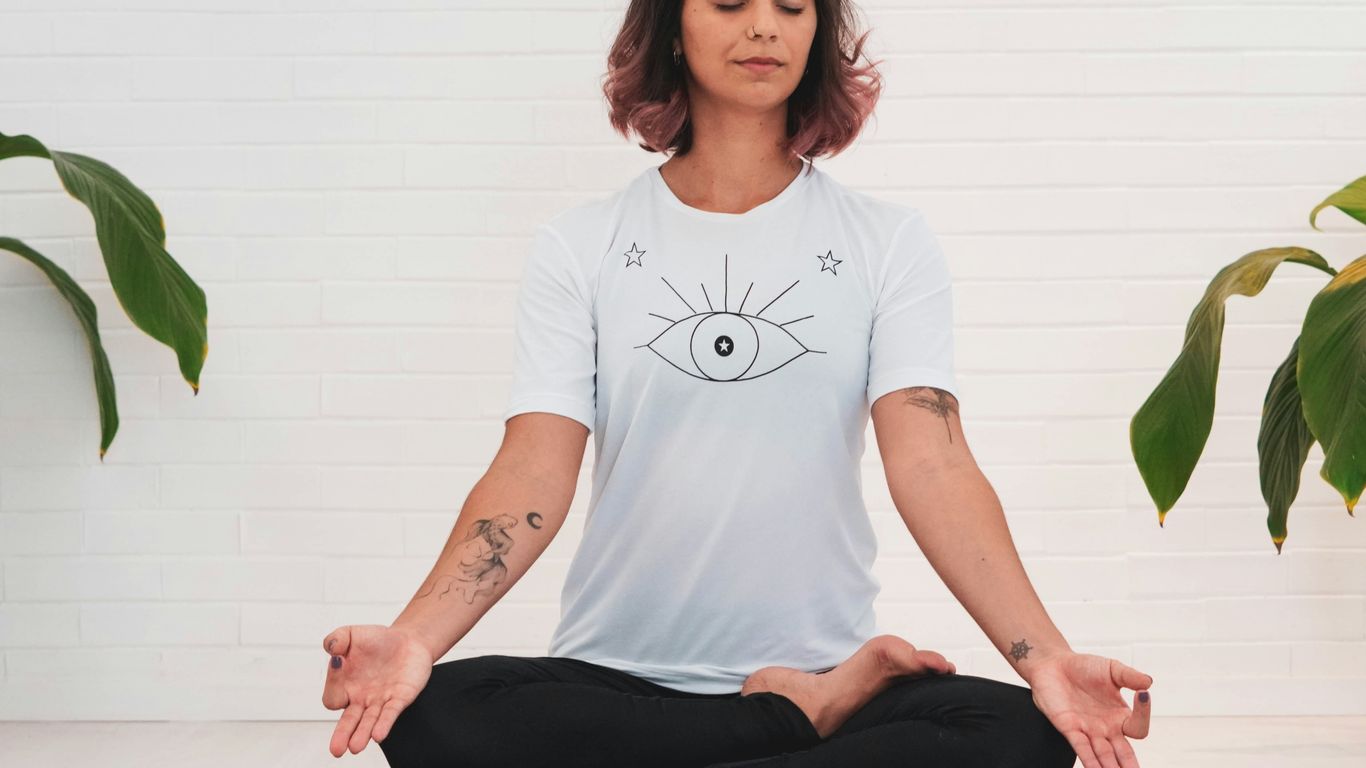 woman in white crew neck t-shirt and black pants sitting on white table