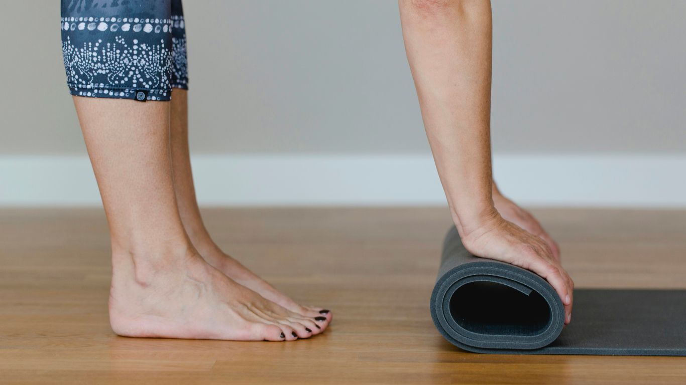 A woman standing on a yoga mat with her feet on the mat