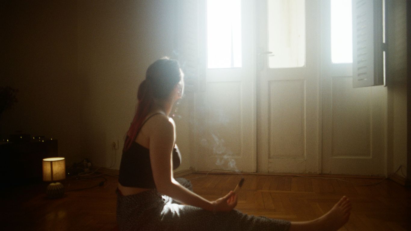 A woman sitting on the floor in front of a window