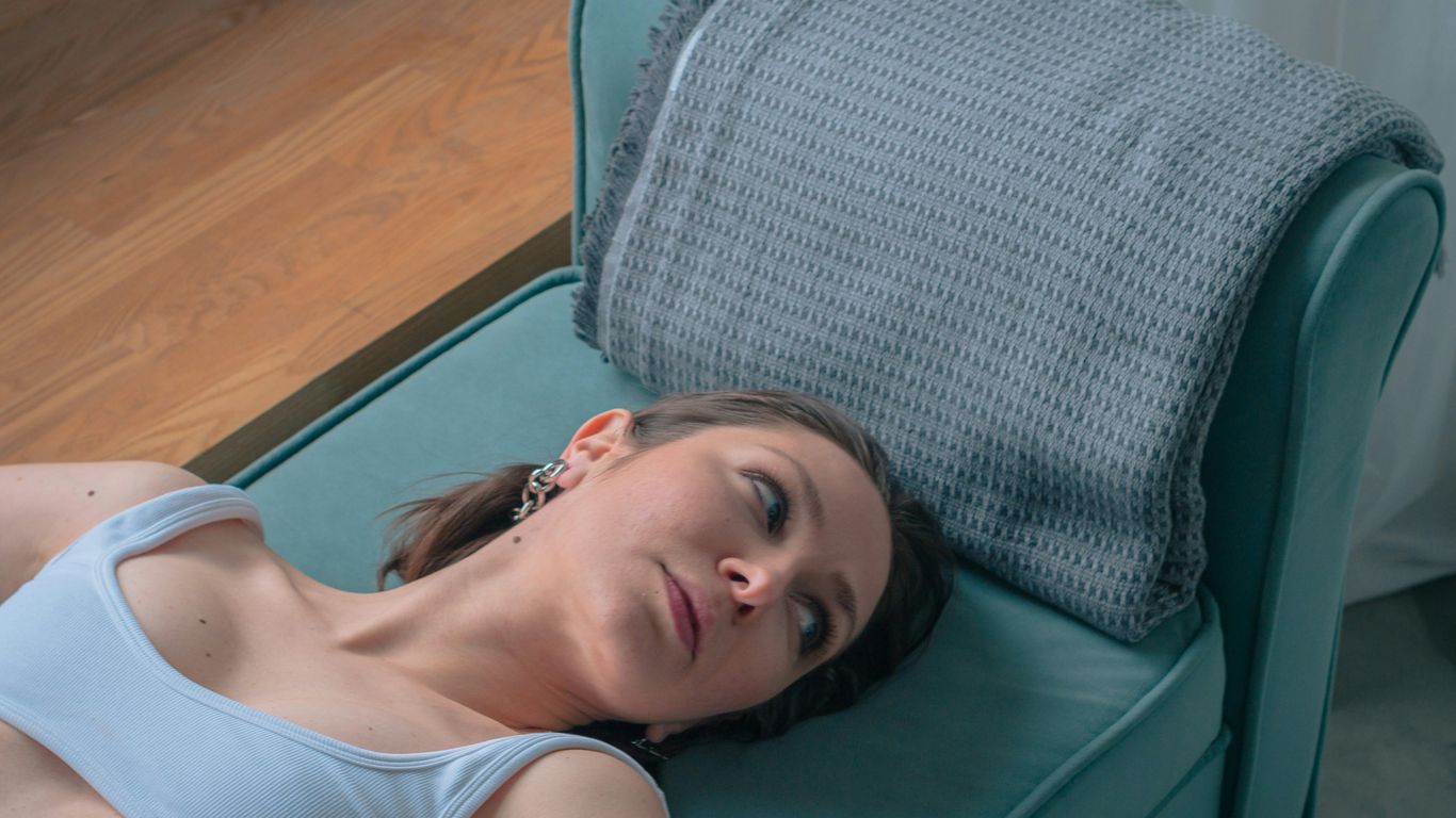 a woman laying on a couch with a pillow