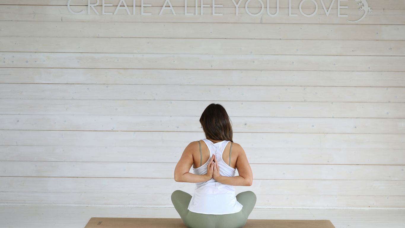 Woman in yoga pose with hands clasped behind back