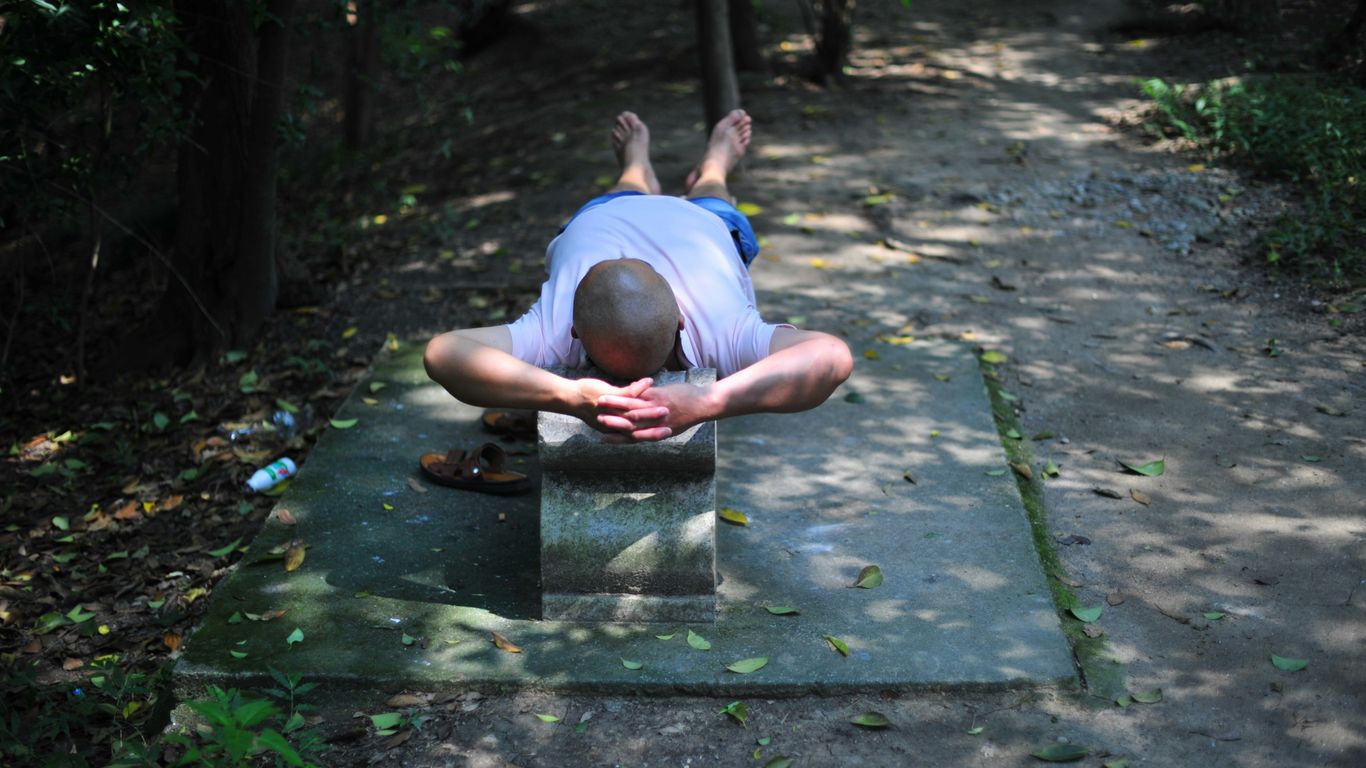 Man resting on concrete structure outdoors