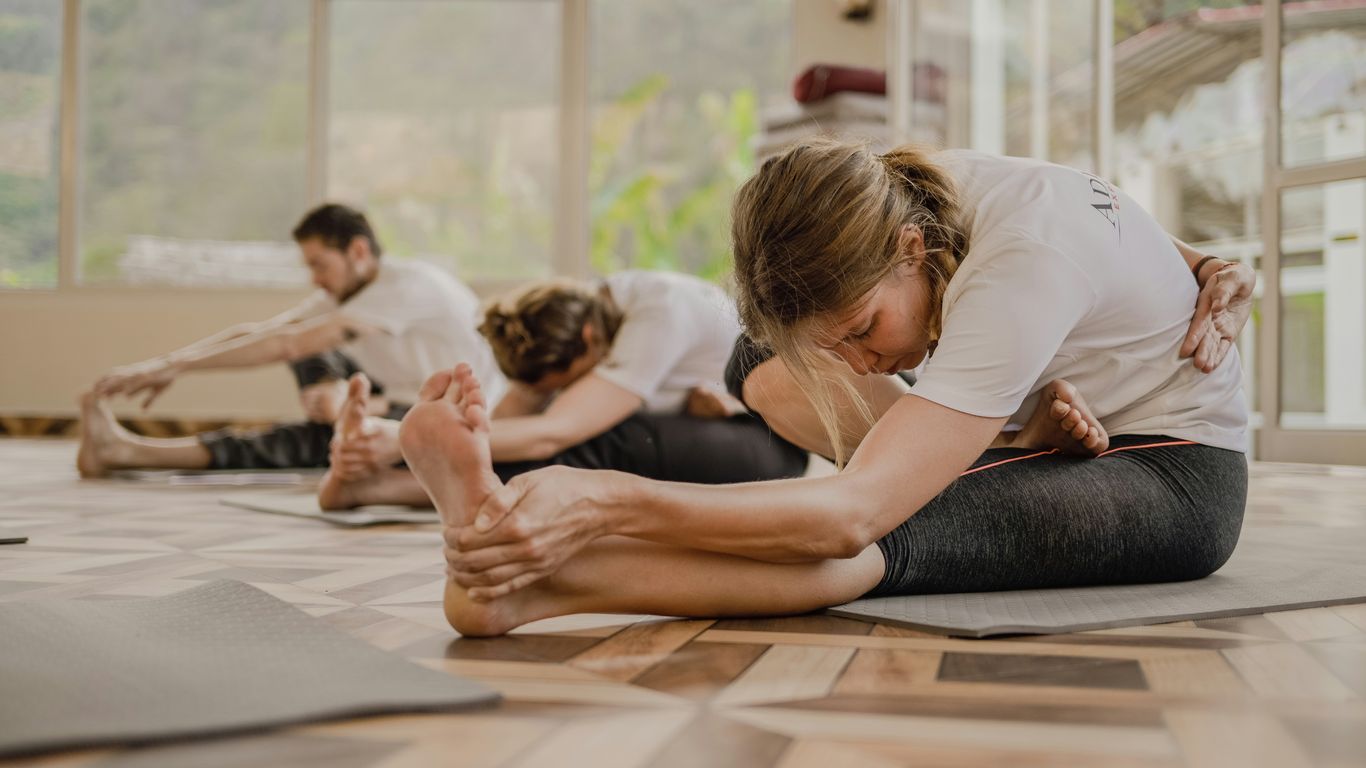 a group of people doing yoga in a room