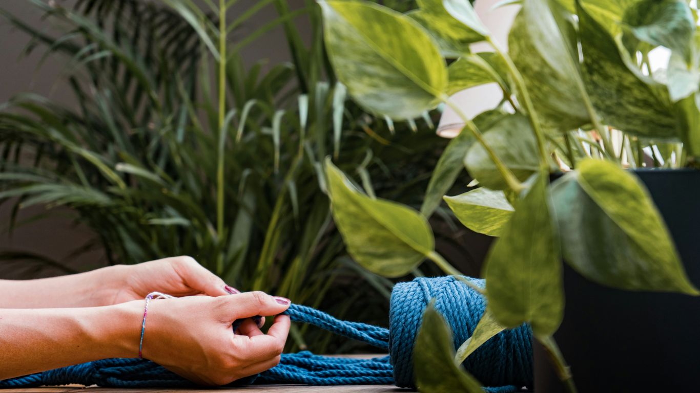 a person tying a blue rope on a table