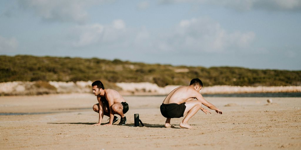 two men sitting on sand