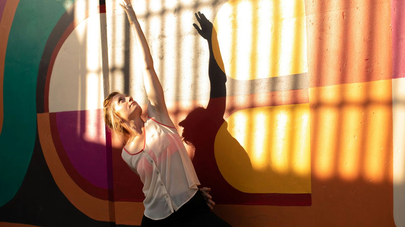 a person standing in front of a colorful wall