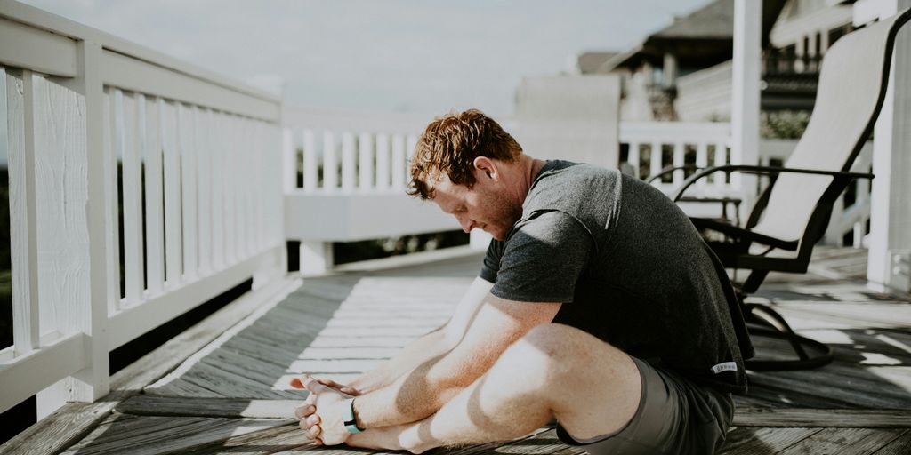 man doing yoga in porch