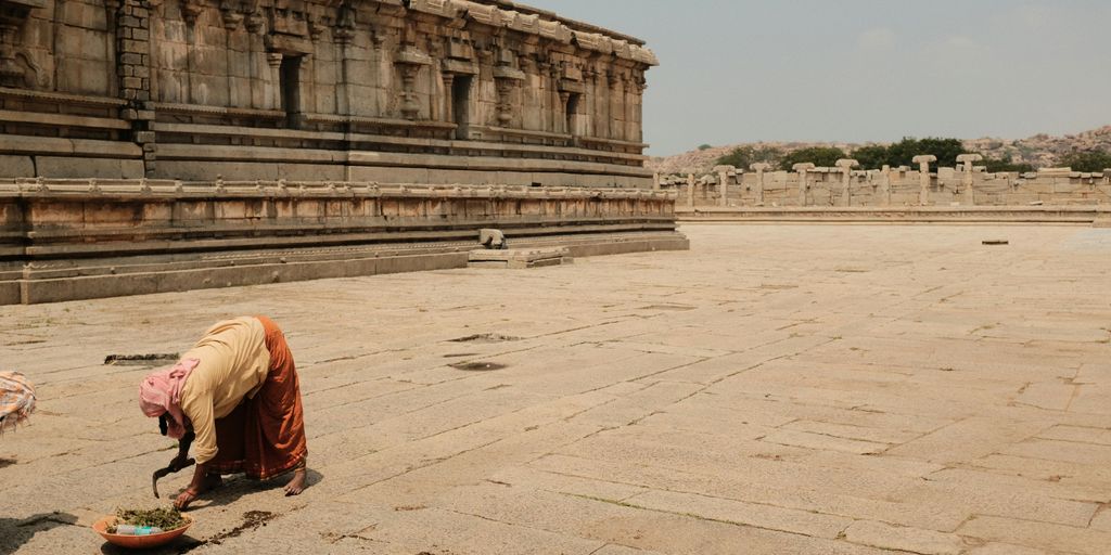 a woman kneeling down on the ground in front of a building