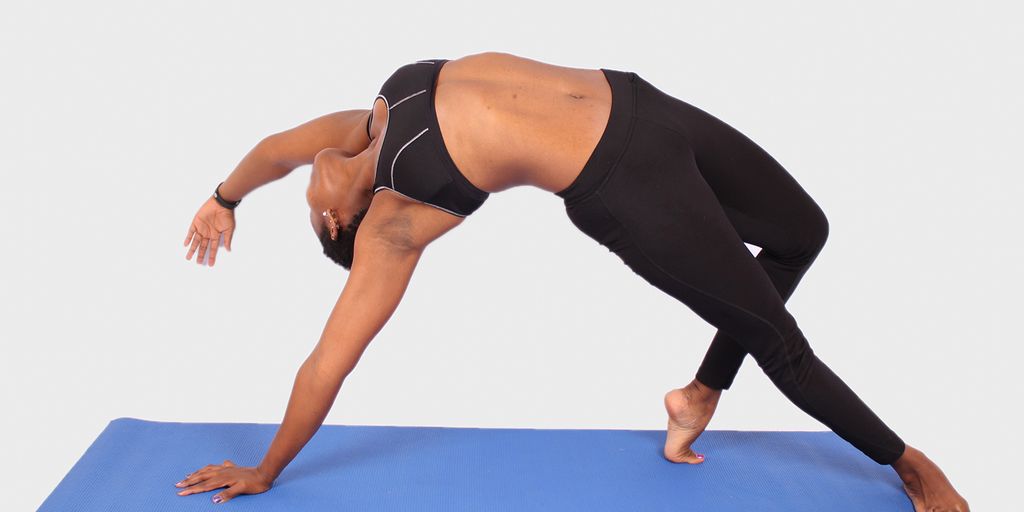 woman practicing yoga on a folding mat in a serene outdoor setting