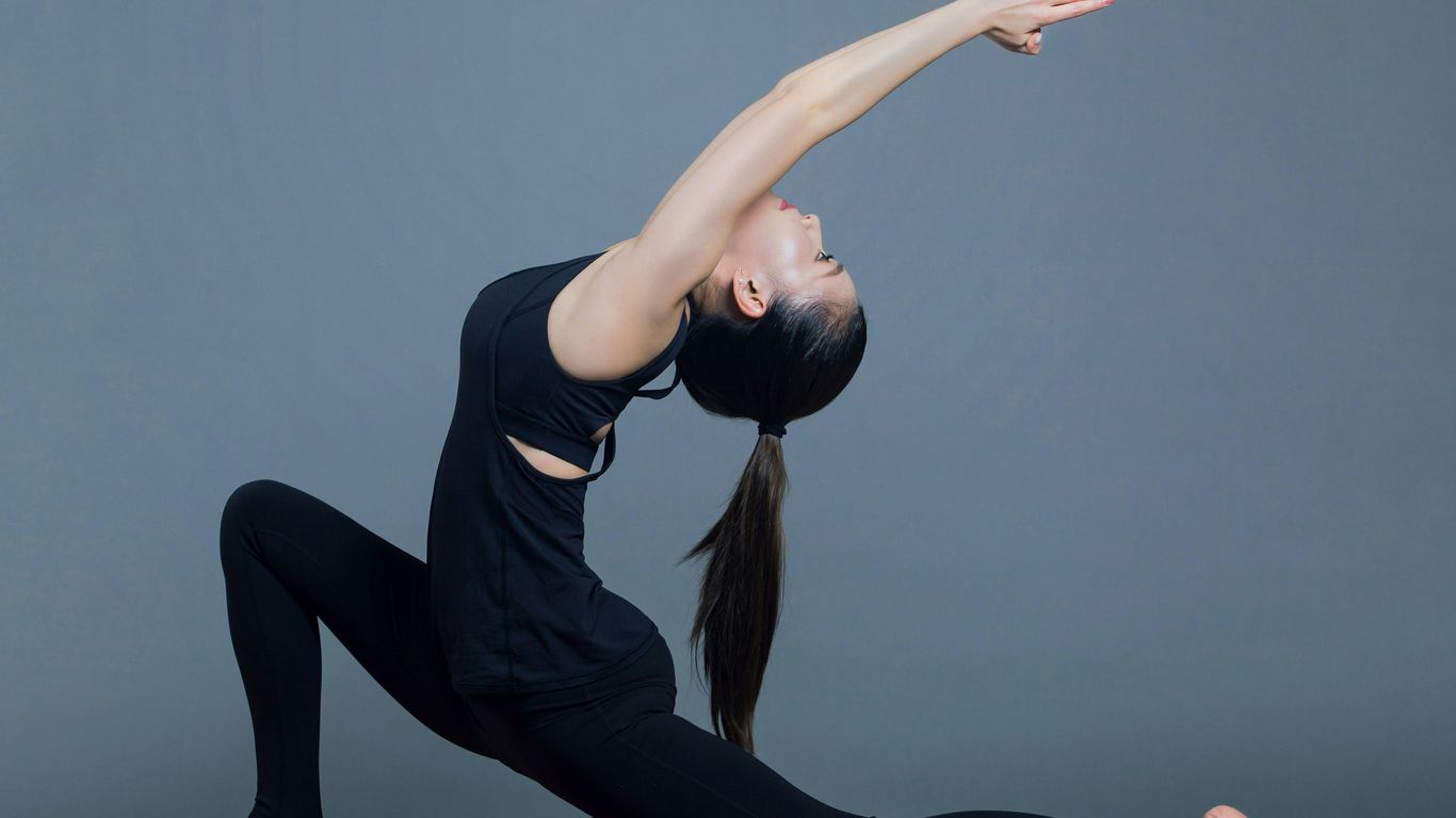 woman in black tank top and black pants doing yoga