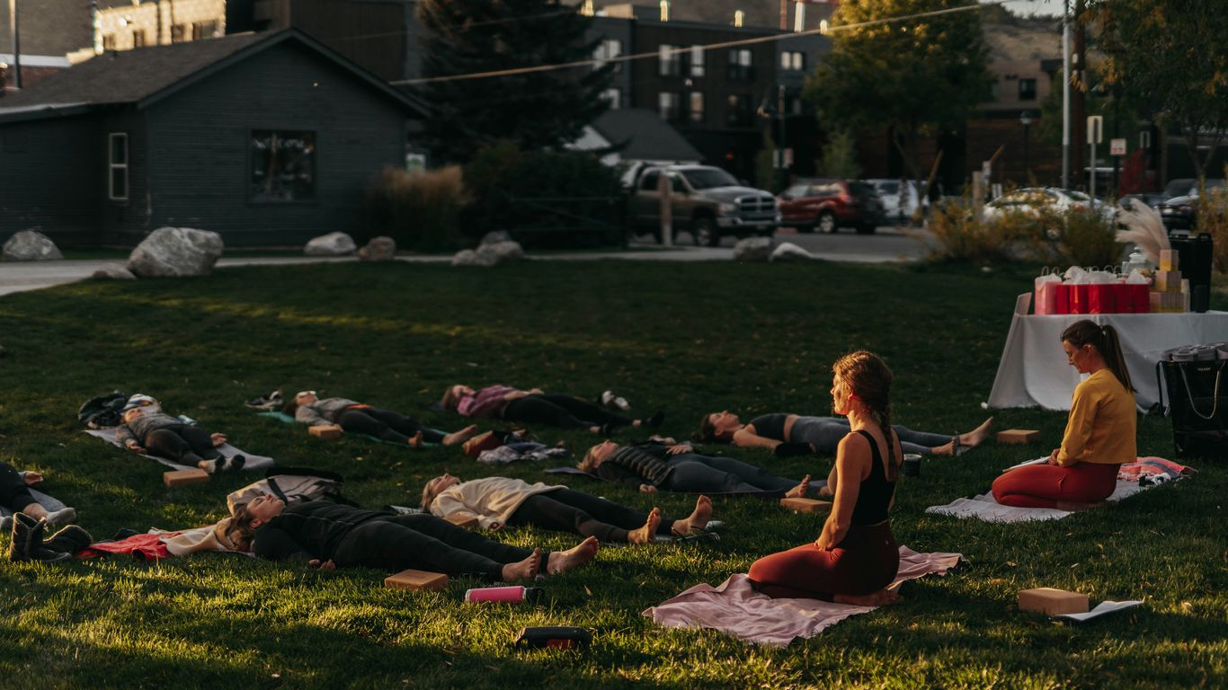 a group of people laying on top of a lush green field