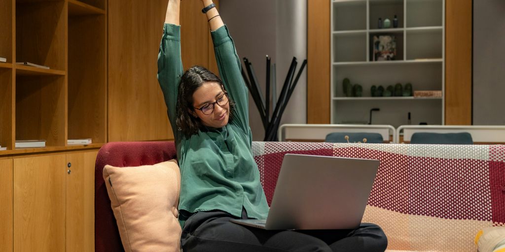 a woman sitting on a couch using a laptop