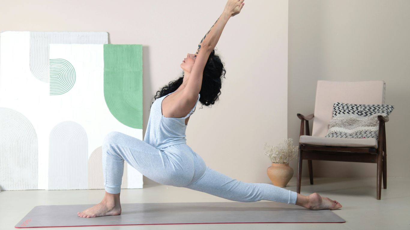 a woman doing a yoga pose in a room