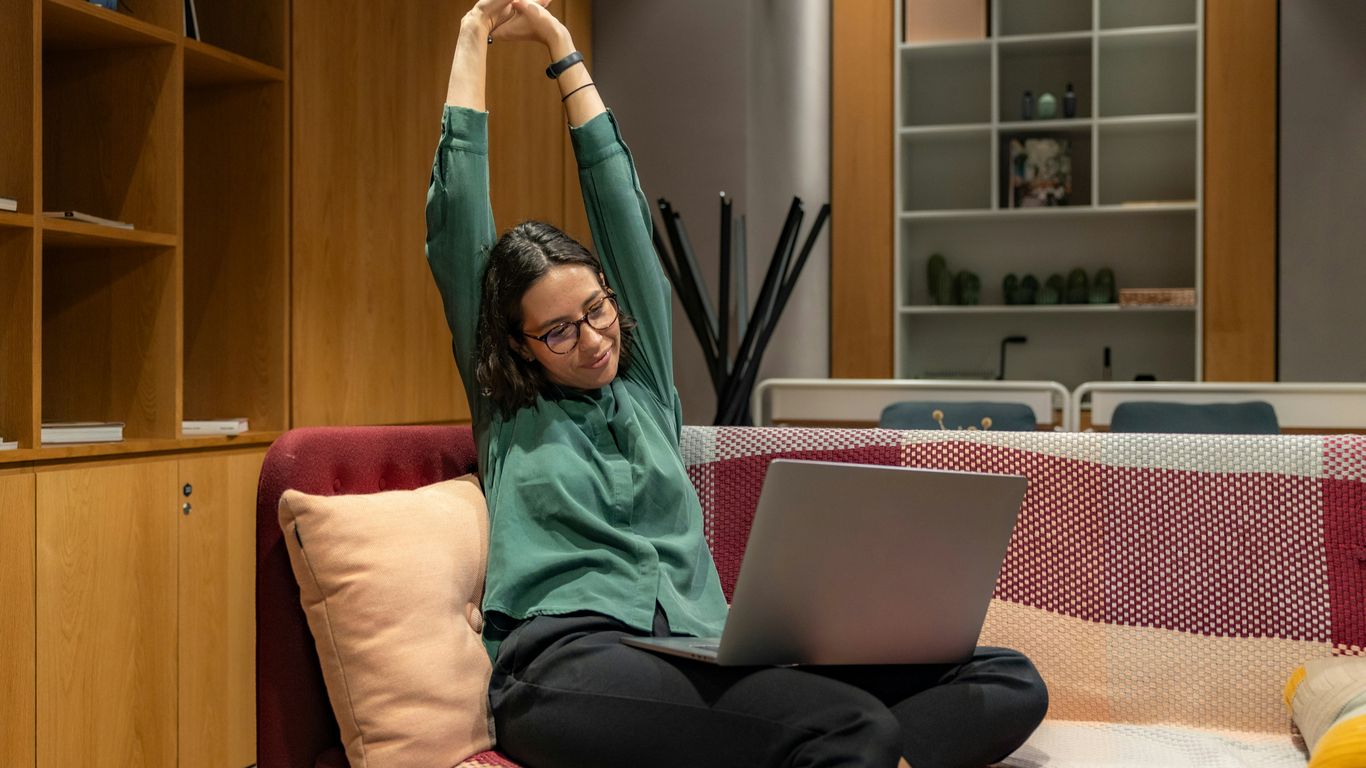 a woman sitting on a couch using a laptop