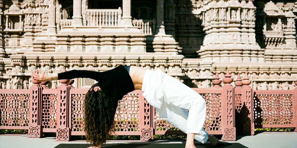 A woman doing a yoga pose in front of a building