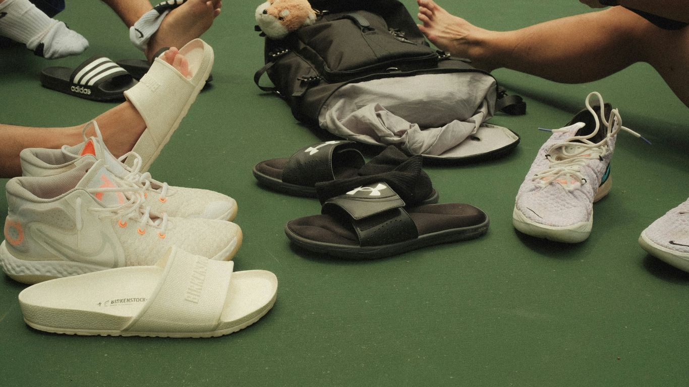 a group of people sitting on the ground with their shoes on