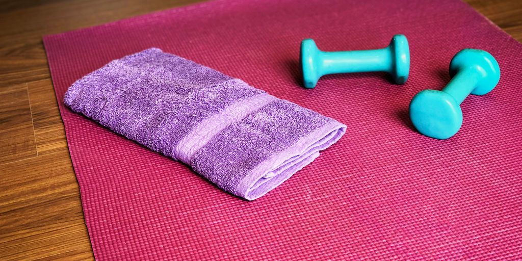Yoga mat, weights, and a towel ready for a workout.