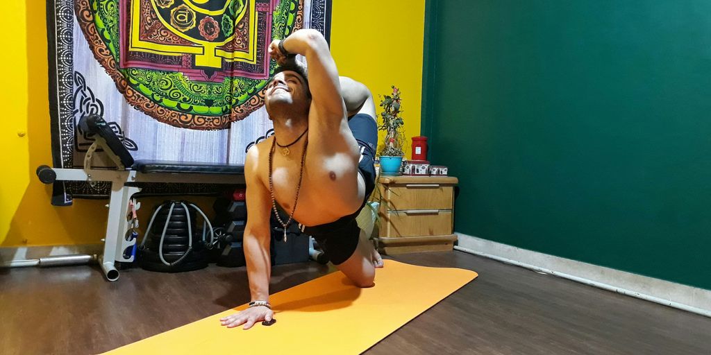topless man in black shorts kneeling on yellow yoga mat